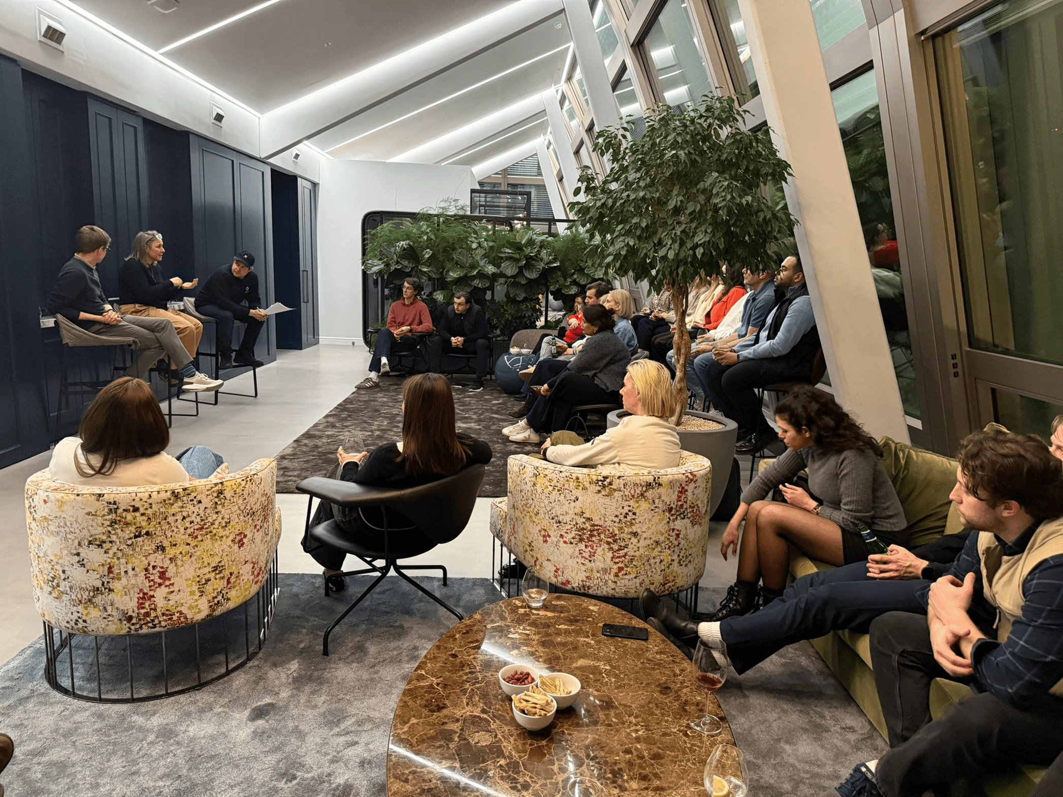 Image of speakers on stage and audience listening